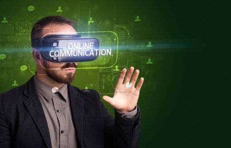 Téléchargez les photos : Homme d'affaires regardant à travers des lunettes de réalité virtuelle avec inscription COMMUNICATION EN LIGNE, concept de réseautage social - en image libre de droit
