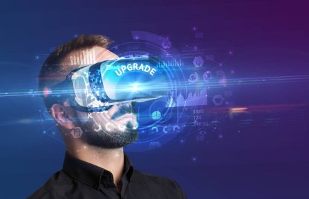 Foto de Hombre de negocios mirando a través de gafas de realidad virtual con inscripción UPGRADE, concepto de tecnología innovadora - Imagen libre de derechos