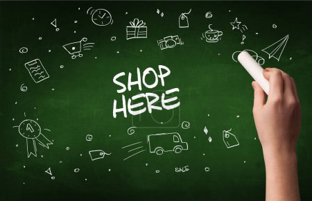 Photo for Hand drawing SHOP HERE inscription with white chalk on blackboard, online shopping concept - Royalty Free Image