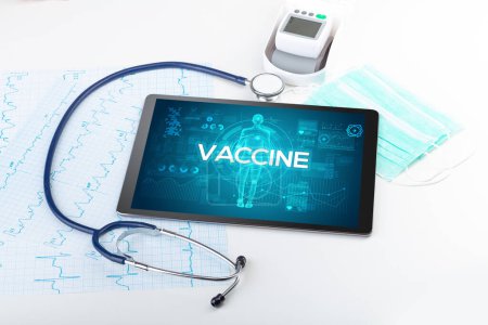 Téléchargez les photos : Tablette pc et outils médicaux avec inscription VACCINE, concept de coronavirus - en image libre de droit