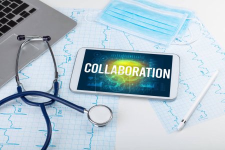Foto de Tablet PC y herramientas médicas con inscripción COLABORACIÓN, concepto de distanciamiento social - Imagen libre de derechos
