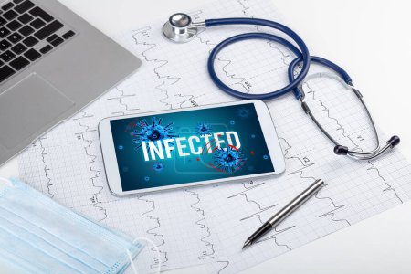 Foto de Tablet PC y herramientas médicas en superficie blanca con inscripción INFECTADA, concepto pandémico - Imagen libre de derechos