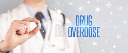 Photo for Close-up of a doctor giving a pill with DRUG OVERDOSE inscription, medical concept - Royalty Free Image