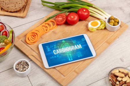 Photo for CARDIOGRAM concept in tablet with fruits, top view - Royalty Free Image