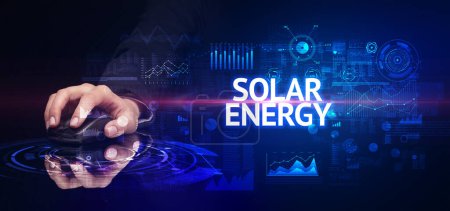 Photo for Hand holding wireless peripheral with SOLAR ENERGY inscription, modern technology concept - Royalty Free Image
