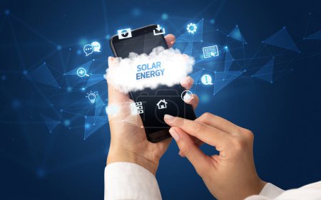 Foto de Smartphone de mano femenina con inscripción SOLAR ENERGY, concepto de tecnología cloud - Imagen libre de derechos