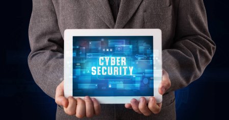 Photo for Young business person working on tablet and shows the digital sign: CYBER SECURITY - Royalty Free Image