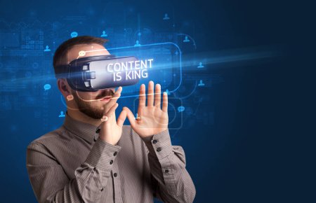 Téléchargez les photos : Homme d'affaires regardant à travers des lunettes de réalité virtuelle avec CONTENU EST ROI inscription, concept de réseautage social - en image libre de droit