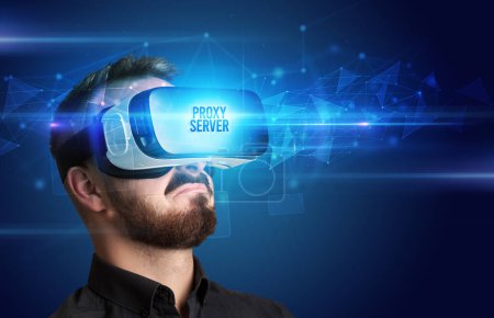 Téléchargez les photos : Homme d'affaires regardant à travers des lunettes de réalité virtuelle avec inscription PROXY SERVER, concept de cybersécurité - en image libre de droit