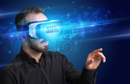 Téléchargez les photos : Homme d'affaires regardant à travers des lunettes de réalité virtuelle avec ACCÈS GRANTED inscription, concept de cybersécurité - en image libre de droit