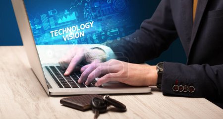 Téléchargez les photos : Homme d'affaires travaillant sur ordinateur portable avec inscription TECHNOLOGY VISION, concept de cybertechnologie - en image libre de droit