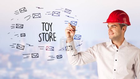 Photo for Handsome businessman with helmet drawing TOY STORE inscription, contruction sale concept - Royalty Free Image