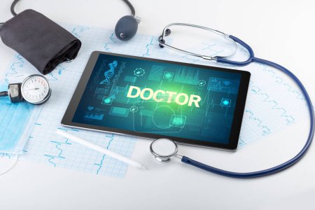 Foto de Tablet PC y material médico con inscripción DOCTOR, concepto de prevención - Imagen libre de derechos