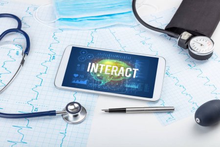 Foto de Tablet PC y herramientas médicas con inscripción INTERACT, concepto de distanciamiento social - Imagen libre de derechos