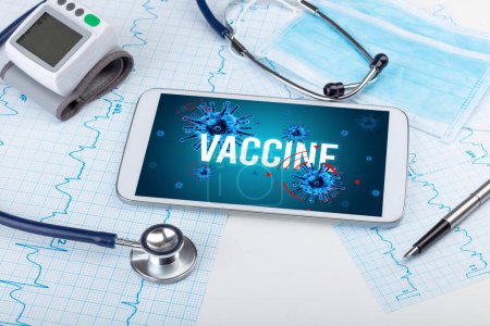 Foto de Tablet PC y herramientas médicas en superficie blanca con inscripción VACCINE, concepto pandémico - Imagen libre de derechos
