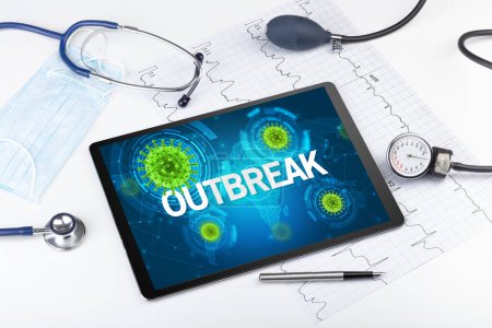 Photo for Close-up view of a tablet pc with OUTBREAK inscription, microbiology concept - Royalty Free Image