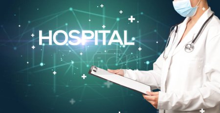 Photo for Doctor fills out medical record with HOSPITAL inscription, medical concept - Royalty Free Image