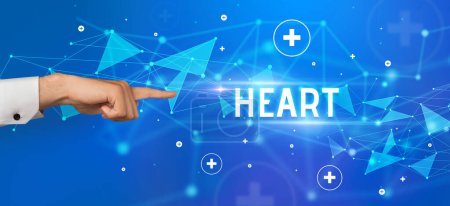 Téléchargez les photos : Gros plan de la main coupée pointant vers l'inscription HEART, concept médical - en image libre de droit