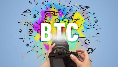 Foto de Primer plano de una cámara digital de mano con dibujo abstracto e inscripción BTC - Imagen libre de derechos