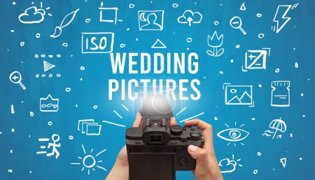 Photo for Hand taking picture with digital camera and WEDDING PICTURES inscription, camera settings concept - Royalty Free Image
