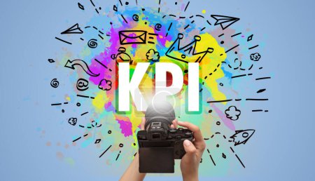 Foto de Primer plano de una cámara digital de mano con dibujo abstracto e inscripción KPI - Imagen libre de derechos