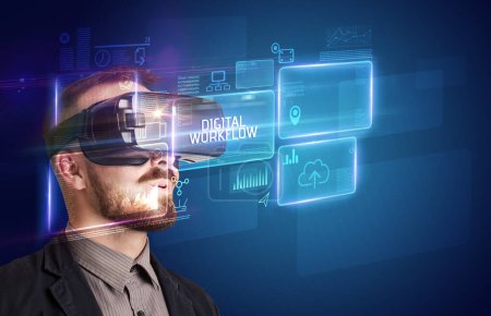 Foto de Hombre de negocios mirando a través de gafas de realidad virtual con inscripción DIGITAL WORKFLOW, concepto de nueva tecnología - Imagen libre de derechos