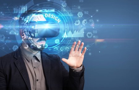 Téléchargez les photos : Homme d'affaires regardant à travers des lunettes de réalité virtuelle avec inscription WEB DESIGN, concept technologique innovant - en image libre de droit