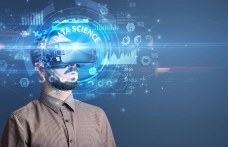 Téléchargez les photos : Homme d'affaires regardant à travers des lunettes de réalité virtuelle avec inscription DATA SCIENCE, concept technologique innovant - en image libre de droit