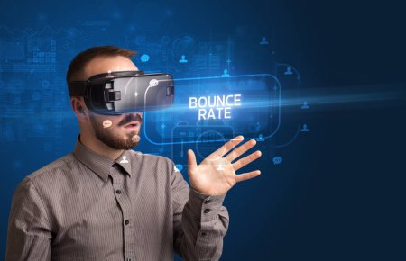 Téléchargez les photos : Homme d'affaires regardant à travers des lunettes de réalité virtuelle avec inscription BOUNCE TAUX, concept de réseautage social - en image libre de droit