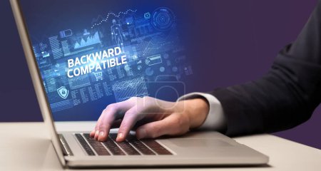 Photo for Businessman working on laptop with BACKWARD COMPATIBLE inscription, cyber technology concept - Royalty Free Image
