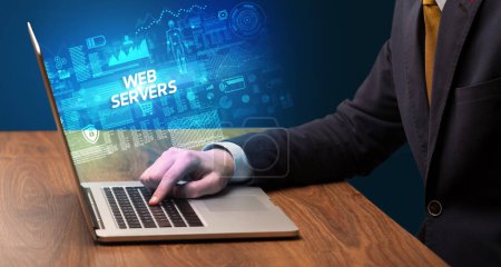 Foto de Empresario trabajando en laptop con inscripción WEB SERVERS, concepto de cibertecnología - Imagen libre de derechos