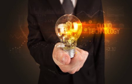 Téléchargez les photos : Homme d'affaires tenant une ampoule avec inscription CLOUD TECHNOLOGY, concept de technologie d'entreprise - en image libre de droit