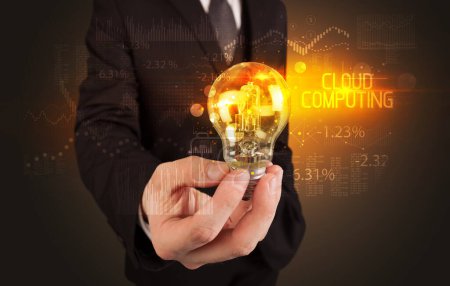 Téléchargez les photos : Homme d'affaires tenant une ampoule avec inscription CLOUD COMPUTING, concept de technologie d'entreprise - en image libre de droit
