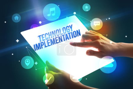 Foto de Soporte de tableta futurista con inscripción de implementación de tecnología, concepto de nueva tecnología - Imagen libre de derechos