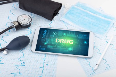 Téléchargez les photos : Tablette pc et matériel médical avec inscription DRUG, concept de prévention - en image libre de droit