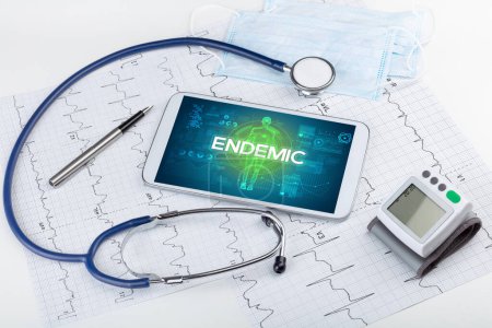 Foto de Tablet PC y herramientas médicas con inscripción ENDEMIC, concepto coronavirus - Imagen libre de derechos