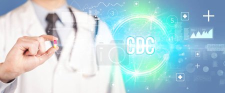 Téléchargez les photos : Gros plan d'un médecin vous donnant une pilule avec l'abréviation CDC, concept de virologie - en image libre de droit
