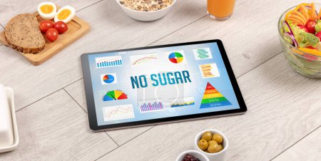 Photo for Organic food and tablet pc showing NO SUGAR inscription, healthy nutrition composition - Royalty Free Image