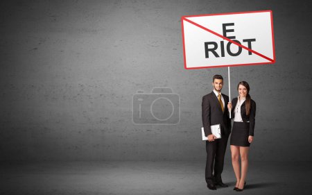 Téléchargez les photos : Homme d'affaires tenant un panneau de signalisation avec inscription E RIOT, nouveau concept d'idée - en image libre de droit
