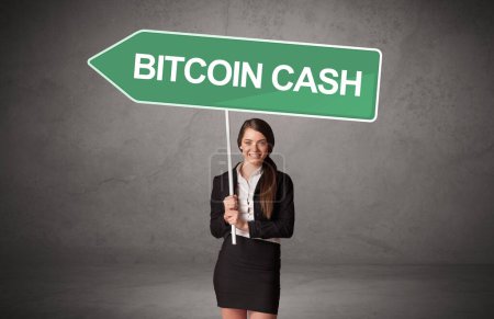 Photo for Young business person in casual holding road sign with BITCOIN CASH inscription, new business direction concept - Royalty Free Image