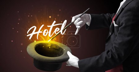 Foto de Mago está mostrando truco de magia con la inscripción del hotel, concepto de viaje - Imagen libre de derechos