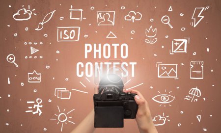 Photo for Hand taking picture with digital camera and PHOTO CONTEST inscription, camera settings concept - Royalty Free Image