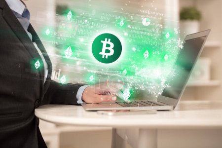 Téléchargez les photos : Jeune homme regardant le marché boursier sur ordinateur portable avec des icônes Bitcoin, concept de forex - en image libre de droit
