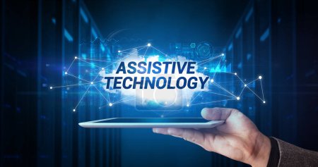 Photo for Young business person working on tablet and shows the inscription: ASSISTIVE TECHNOLOGY - Royalty Free Image