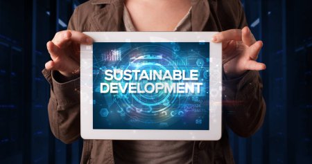 Photo for Young business person working on tablet and shows the inscription: SUSTAINABLE DEVELOPMENT, business concept - Royalty Free Image