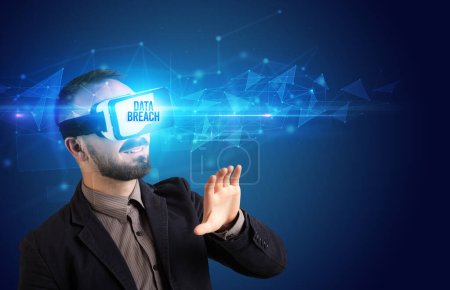 Téléchargez les photos : Homme d'affaires regardant à travers des lunettes de réalité virtuelle avec inscription DATA BREACH, concept de cybersécurité - en image libre de droit
