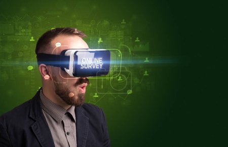 Photo for Businessman looking through Virtual Reality glasses with ONLINE SURVEY inscription, social networking concept - Royalty Free Image
