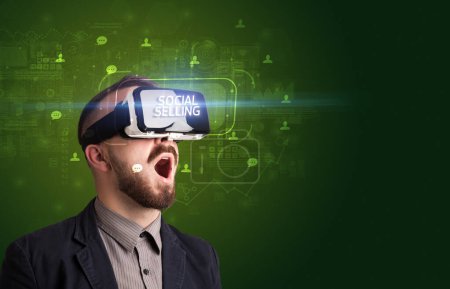 Téléchargez les photos : Homme d'affaires regardant à travers des lunettes de réalité virtuelle avec inscription VENTE SOCIALE, concept de réseautage social - en image libre de droit