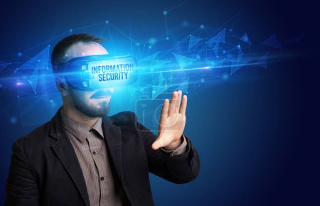 Téléchargez les photos : Homme d'affaires regardant à travers des lunettes de réalité virtuelle avec inscription INFORMATION SECURITY, concept de cybersécurité - en image libre de droit