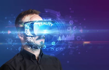 Téléchargez les photos : Homme d'affaires regardant à travers des lunettes de réalité virtuelle avec inscription REALITY, concept technologique innovant - en image libre de droit